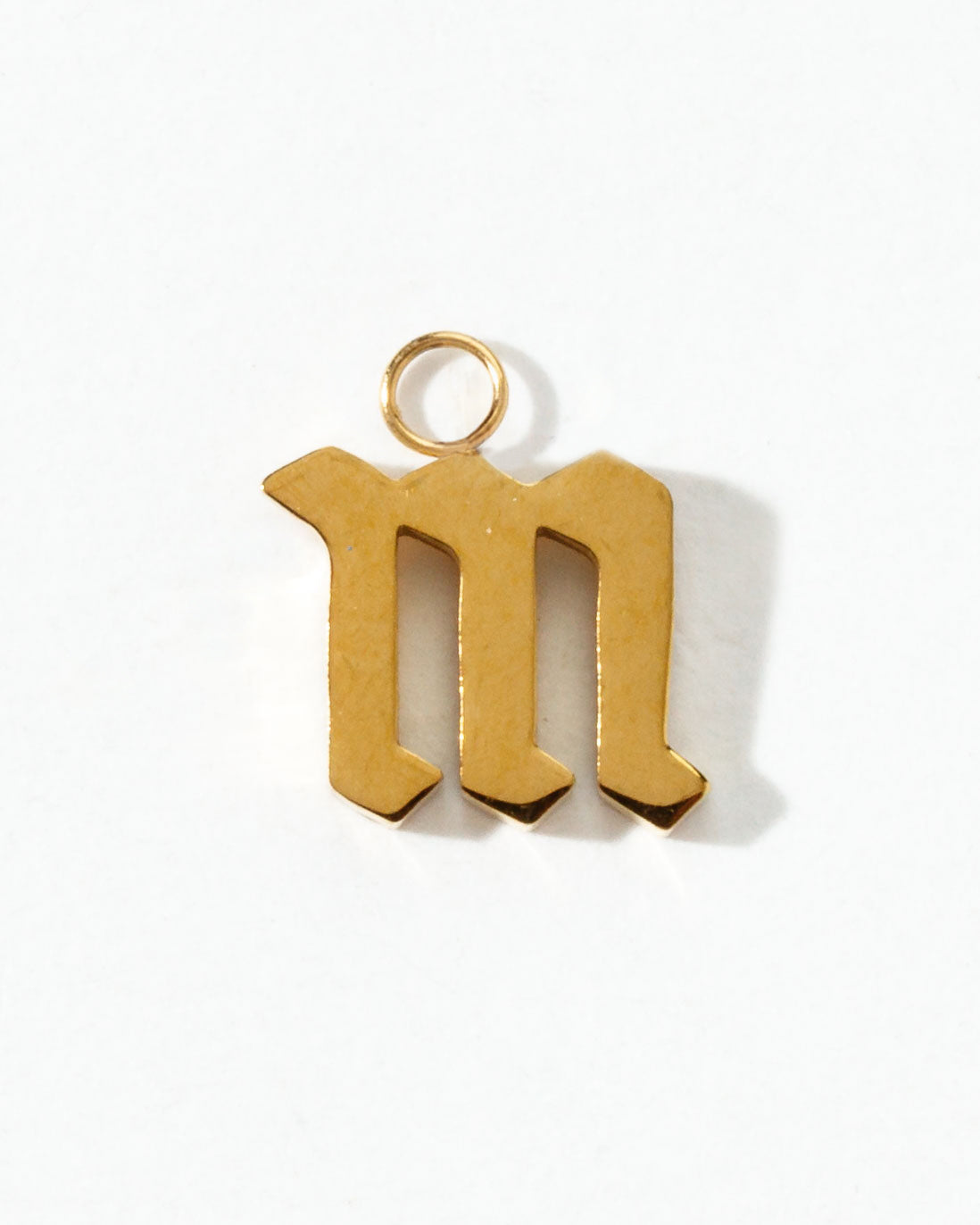 Gold letter 'm' pendant on a white background