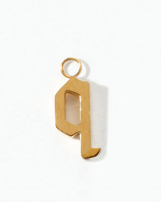 Gold letter "q" charm on a white background.