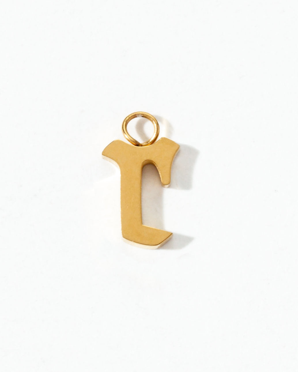 Gold letter "r" charm on a white background.
