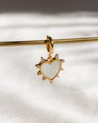 Gold heart-shaped pendant with a white center on a white background
