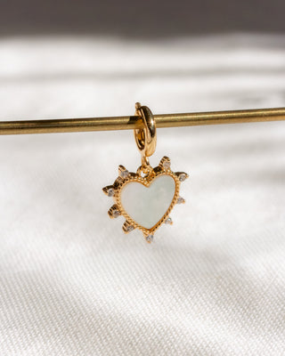 Gold heart-shaped pendant with a white center on a white background