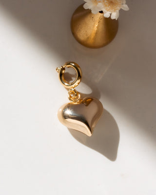 Gold heart-shaped charm on a light background