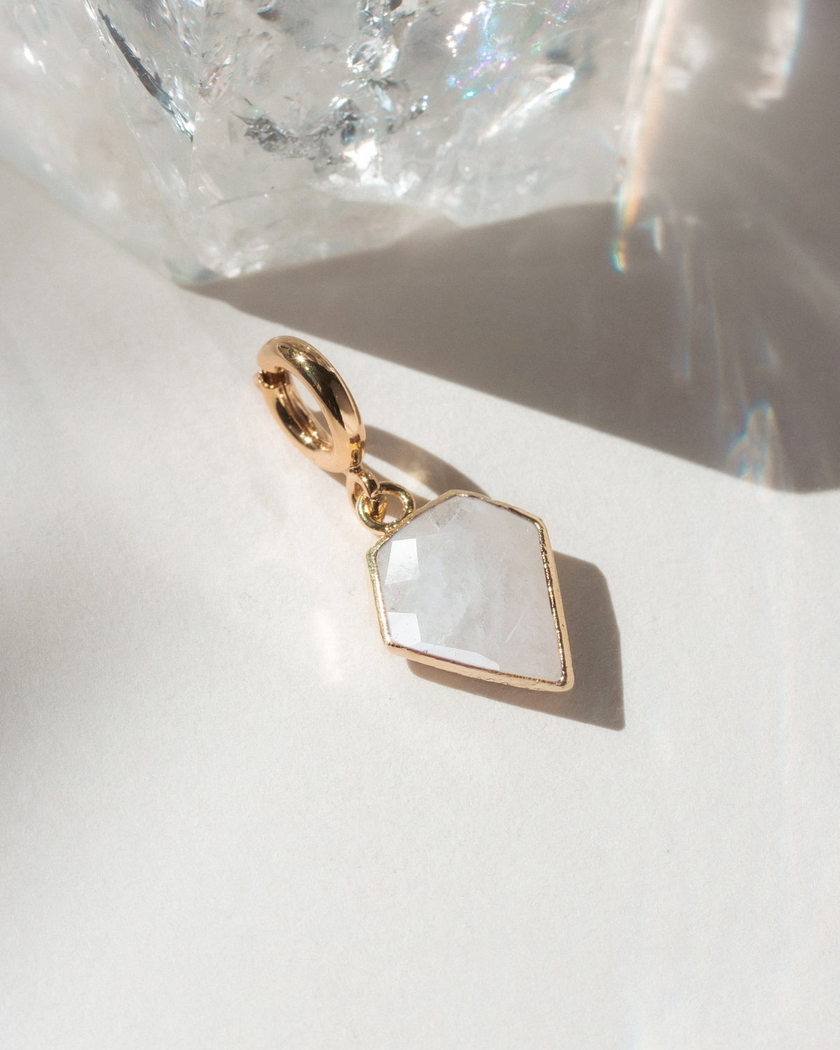 Gold charm with a geometric design on a white surface