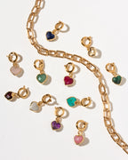 Gold heart-shaped charm clips with various colored gemstones, displayed on a clean white background with a gold paperclip chain.