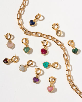 Gold heart-shaped charm clips with various colored gemstones, displayed on a clean white background with a gold paperclip chain.