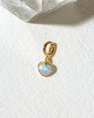 A small gold heart charm in iridescent blue-white moonstone.