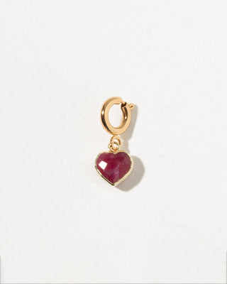 Gold hoop earring with a ruby heart charm on a white background