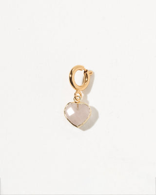 Gold charm with a heart-shaped pink rose quartz stone on a white background