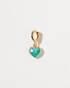 Gold heart-shaped pendant with turquoise stone on a light gray background