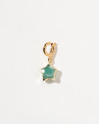Gold charm with a green star-shaped gem on a white background