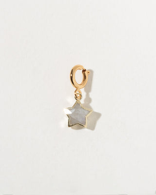 Gold charm with a star-shaped stone on a white background