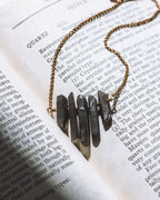 Necklace with black geometric pendants on an open book