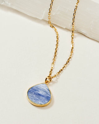 A gold chain necklace with a teardrop-shaped pendant featuring a blue and white marbled kyanite stone in a gold bezel setting.