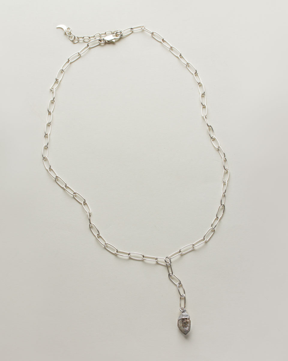 Silver chain necklace with herkimer quartz pendant on a white background.