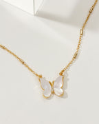 Gold necklace with a butterfly pendant on a white background