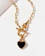 Gold chain necklace with a toggle clasp and black onyx heart padlock pendant