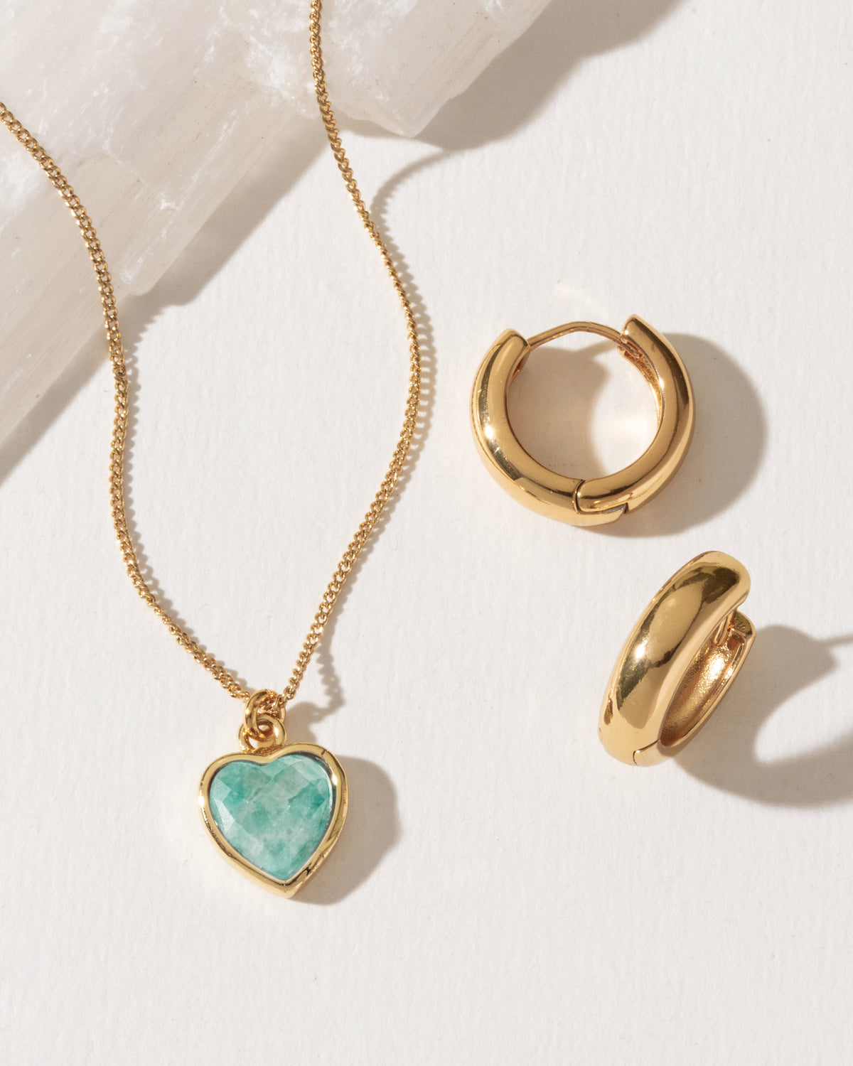 Set of gold hoop earrings and a necklace with a heart-shaped amazonite pendant