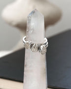 Three stacked silver rings with herkimer quartz gemstones displayed on a crystal tower.