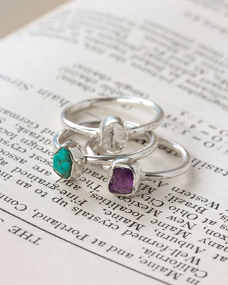 silver ring herkimer, turquoise and amethyst 3 ring stacking set laid on top of book