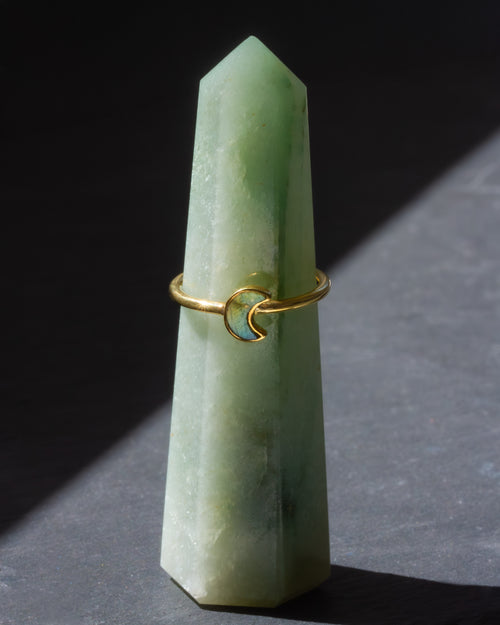 Gold ring with a moon design on a green crystal