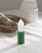 Green and white crystal on a white surface with a blurred background