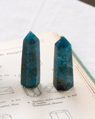 Two blue crystal points on a book with geometric drawings