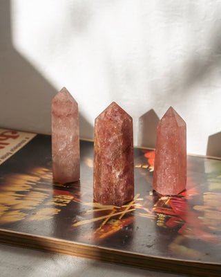 Three pink crystal towers on a decorative surface with a blurred background