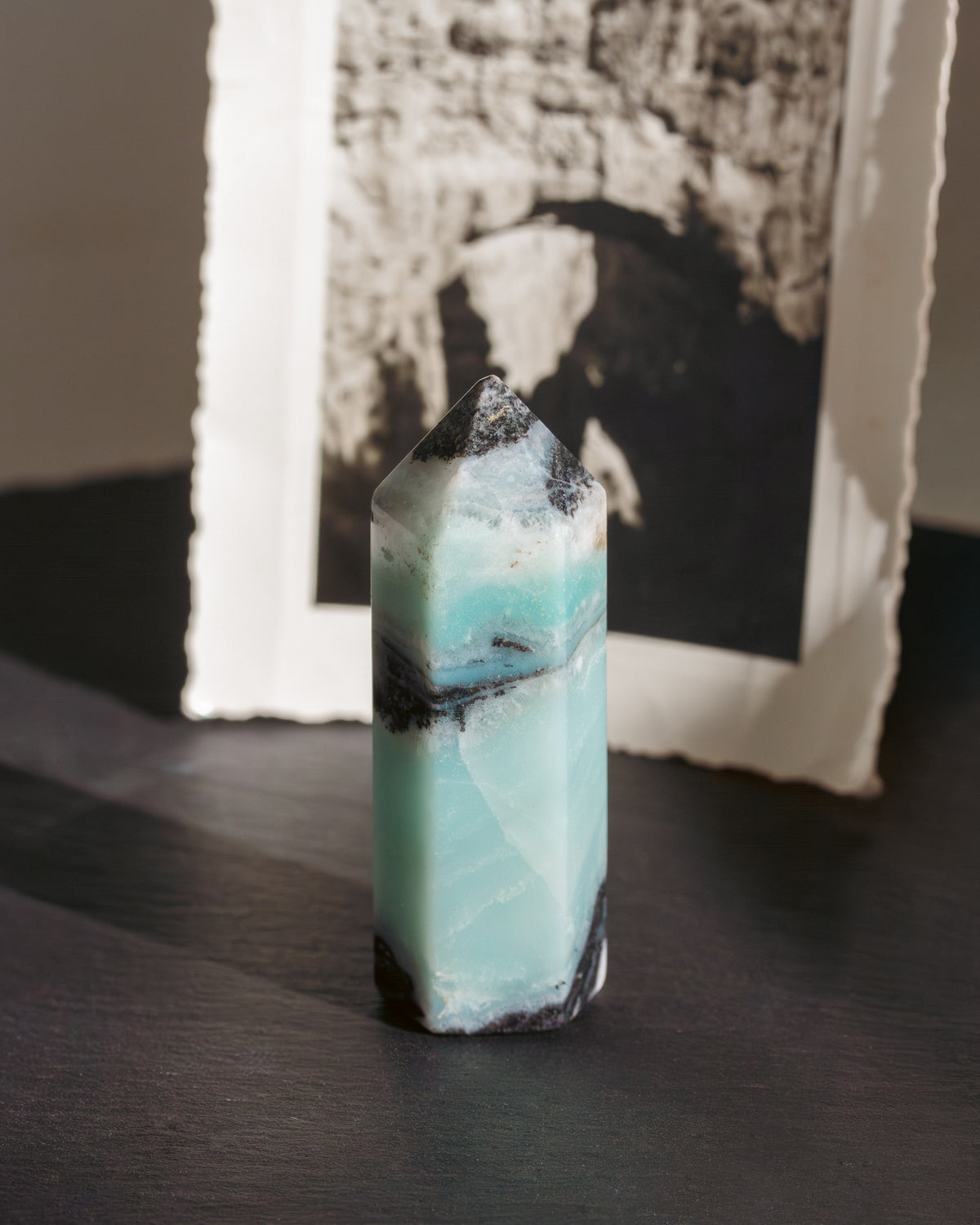 Mint varied color standing crystal on a dark surface