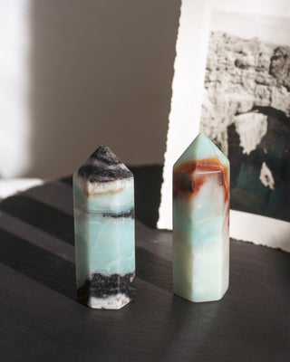 Two crystal towers on a dark surface with a blurred background