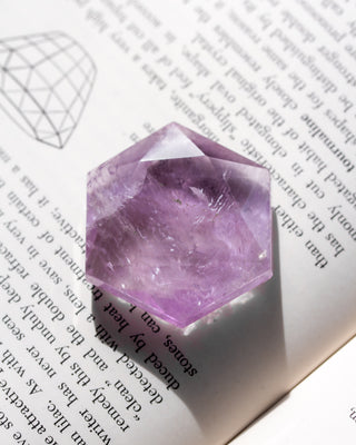 Amethyst crystal on a book with text