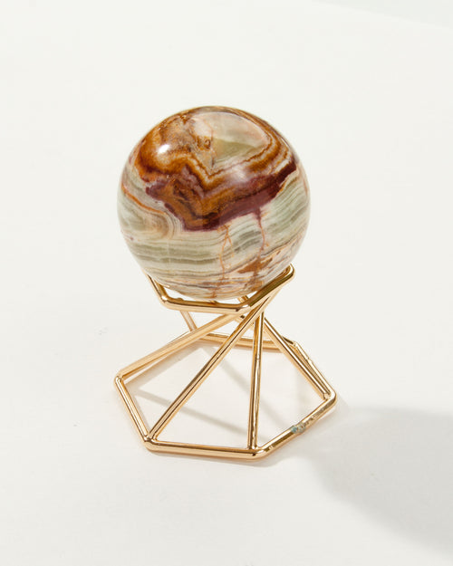 Banded Calcite sphere with brown, white and light green bands, resting on a gold metal stand.