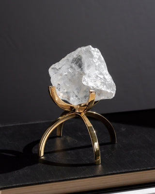 Clear crystal rock on a gold stand against a black background
