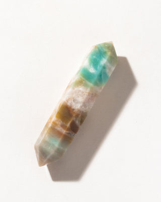 Decorative Quartzite double point wand crystal with green-blue and golden brown patterns on a white background