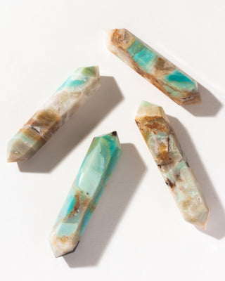 Four decorative Quartzite double point wand crystal with green-blue and golden brown patterns on a white background