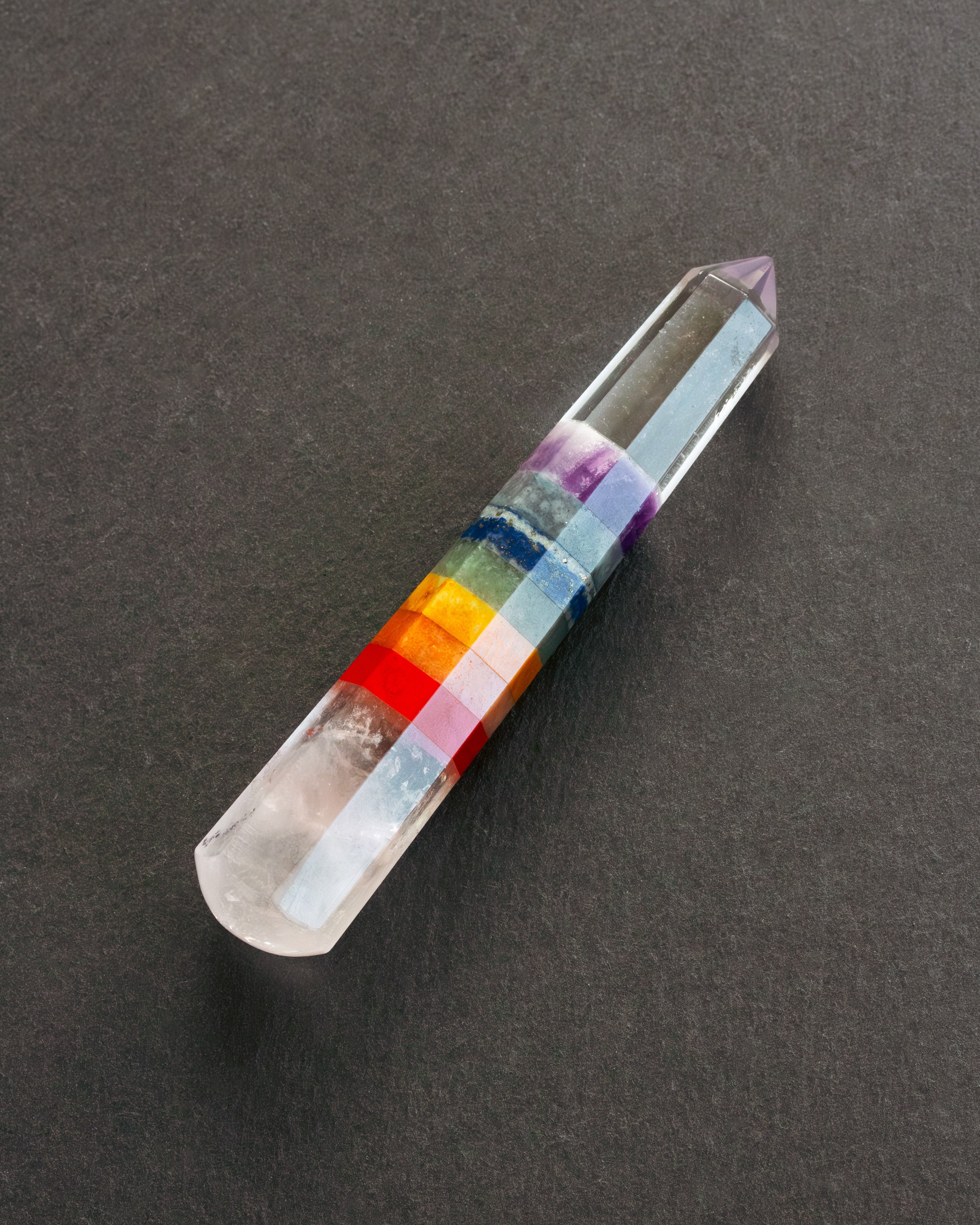 Crystal with color bands on a dark gray background