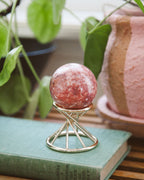 Pink Calcite sphere on a gold stand.