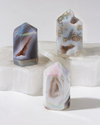 Three crystal-like objects with iridescent and natural patterns on a white background