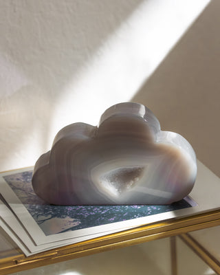 Decorative cloud-shaped object on a shelf with a soft light background