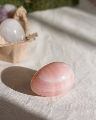 Pink egg shaped gemstone on table