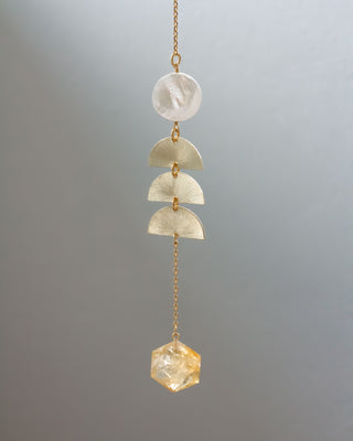 Crystal pendant with gold chain on a gray background
