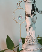 Decorative hanging crystal with a statue in the background