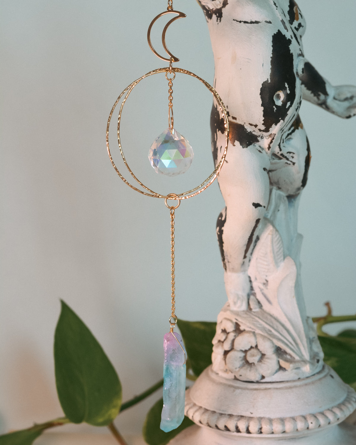 Decorative hanging crystal with a statue in the background