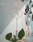 Decorative hanging crystal with a statue and plant in the background