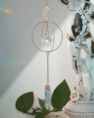 Decorative hanging crystal with a statue and plant in the background