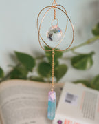 Decorative hanging crystal with gold chain on a blurred background