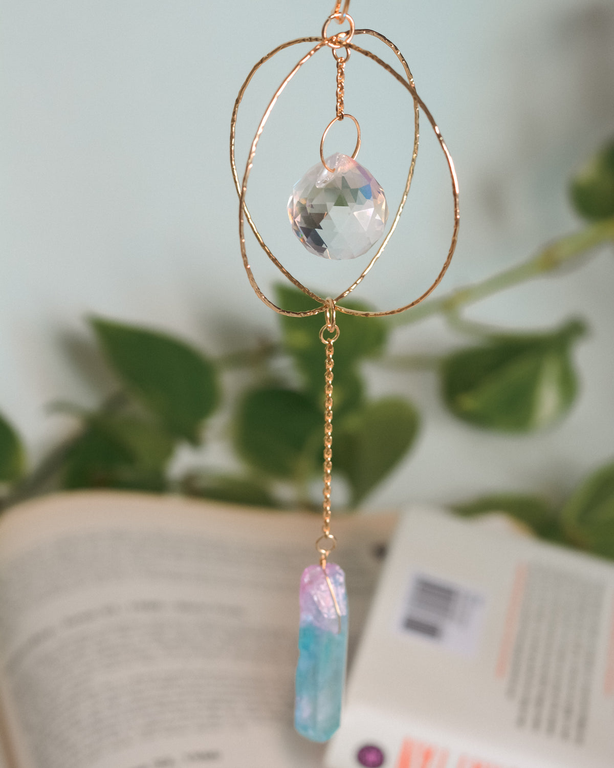 Decorative hanging crystal with gold chain on a blurred background