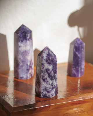 Three purple crystal towers on a wooden surface.