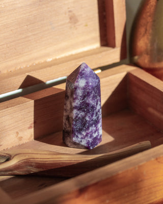 Purple crystal in a wooden box with sunlight filtering through