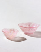 Two nested rose quartz bowls with a subtle wavy pattern