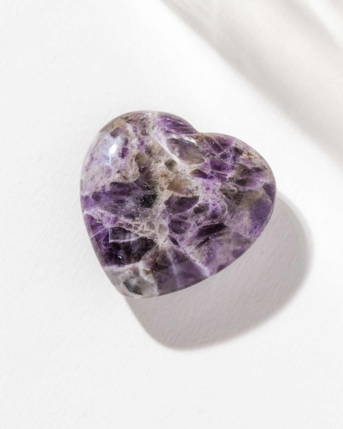 A heart-shaped Chevron Amethyst gemstone with a purple and white pattern
